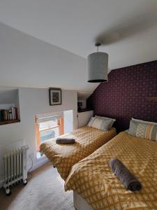 Abernethy的住宿－Pitcaithly Cottage，一间卧室设有两张床和窗户。