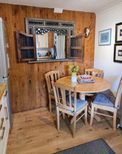Abernethy的住宿－Pitcaithly Cottage，厨房以及带木桌和椅子的用餐室。