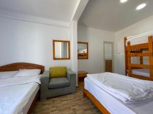 a bedroom with two beds and a chair and a ladder at Auski Hostel Dahab in Dahab