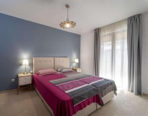 a bedroom with a large bed and a window at Villa 44 SozopoliS in Sozopol