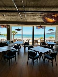 a restaurant with tables and chairs and the beach at Sea Star Budva in Budva