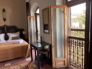 sypialnia z łóżkiem i stołem obok okna w obiekcie Villa Garance w mieście As-Suwajra