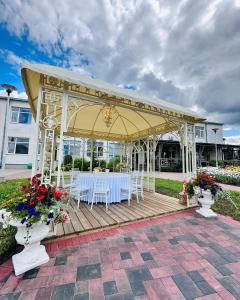 a gazebo with white tables and chairs on it at Silene Resort & SPA Egles Villa in Silene
