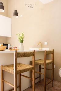 una cucina con due sedie a bancone con lavandino di Nomad Houses - Casa Sarilho a Beja