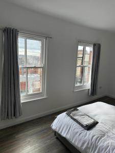 a white bedroom with two windows and a bed at Immaculate 1-Bed Apartment in Northampton in Northampton