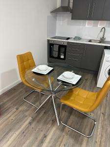 北安普敦的住宿－Immaculate 1-Bed Apartment in Northampton，厨房配有两把椅子、一张桌子和一个水槽