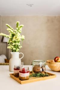 un tagliere con barattoli di marmellata e un vaso con una mela di Nomad Houses - Casa Sarilho a Beja