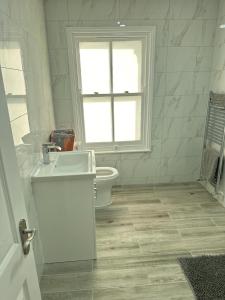 a bathroom with a toilet and a sink and a window at Immaculate 1-Bed Apartment in Northampton in Northampton