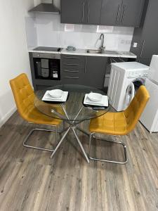 uma cozinha com uma mesa, 2 cadeiras e um lavatório em Immaculate 1-Bed Apartment in Northampton em Northampton