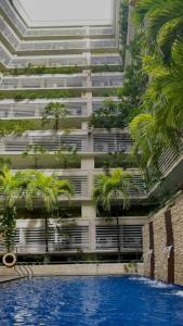 馬尼拉的住宿－150 Newport boulevard，一座棕榈树和游泳池的建筑