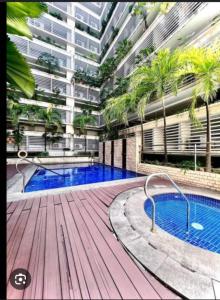 a large apartment building with a swimming pool and palm trees at 150 Newport boulevard in Manila
