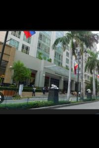 150 Newport boulevard في مانيلا: مبنى كبير أمامه نخلة