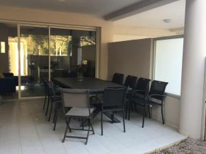 een eetkamer met een zwarte tafel en stoelen bij Appartement avec terrasse à 150m de la plage in Calvi