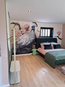 1 dormitorio con un gran mural de pavo real en la pared en Hooischuur Wakker, en Eemnes