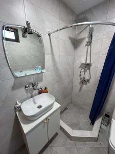 y baño con lavabo y ducha con espejo. en Luca's Apartment in old tbilisi, en Tiflis