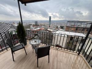 balcón con mesa, sillas y vistas en Luca's Apartment in old tbilisi, en Tiflis