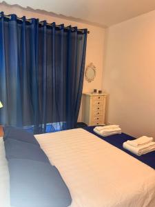 普拉亞達維多利亞的住宿－Apartamento Vitória，一间卧室配有一张带蓝色窗帘的大床