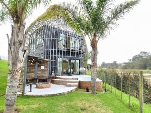 a house with a round building with palm trees at Buff & Fellow Eco Cabins in George