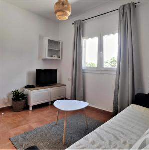 uma sala de estar com uma cama, uma mesa e uma televisão em Apartamento Maria B em Costa Teguise