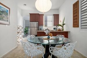 a kitchen with a glass table and chairs at Seaside Caribbean Comfort - Between Beach and City in San Juan