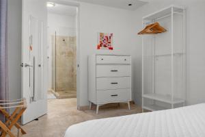 a bedroom with a white dresser and a closet at Seaside Caribbean Comfort - Between Beach and City in San Juan