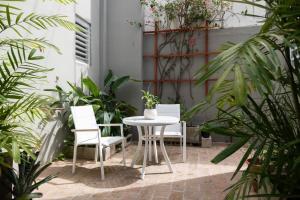 a patio with a table and chairs and plants at Seaside Caribbean Comfort - Between Beach and City in San Juan