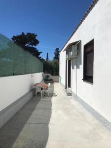 um edifício branco com uma mesa e um banco em villa mediterranea em Realmonte