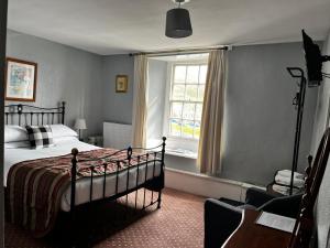 a bedroom with a bed and a window at Black Bull Hotel in Reeth