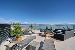 a patio with a couch and chairs on a balcony at Angie's Rooftop Apartment in Slatine