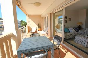 a balcony with a table and chairs in a living room at Apartment 2 bedrooms 2 bathrooms clear view in Palm beach area in Cannes