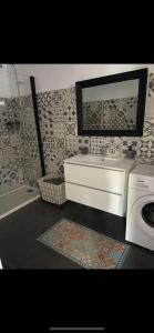 a bathroom with a sink and a washing machine at Appartement proche du départ du GR20 in Calenzana