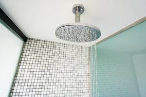 a shower with aendant light and a tiled wall at HF Fénix Music in Lisbon