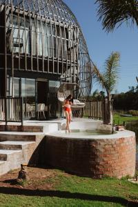 a woman standing in a fountain in front of a building at Buff & Fellow Eco Cabins in George