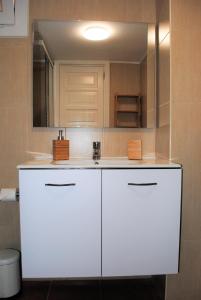 uma cozinha branca com um lavatório e um espelho em Apartamento Maria B em Costa Teguise