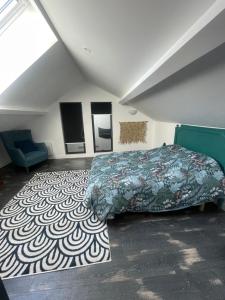a bedroom with a bed and a rug at L'ATELIER YPORT in Yport