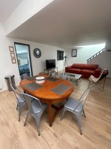 a living room with a wooden table and chairs at L'ATELIER YPORT in Yport