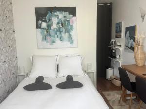 Chambre d hôte - Bambou في سان مور دي فوس: غرفة نوم بها سرير وعليه قبعتين
