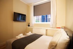 a bedroom with a bed and a television and a window at Stunning 2 bedroom Apt. Heart of the city! in Amsterdam