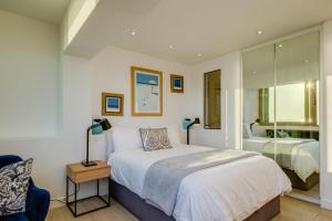 Un dormitorio con una cama grande y un espejo. en Sundowner Views, en Ciudad del Cabo 21 fotos más