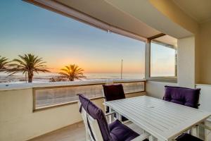 stolik i krzesła w pokoju z widokiem na ocean w obiekcie Sundowner Views w Kapsztadzie