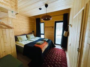 una camera da letto con letto in una camera in legno di Kimmelvilla Pyhä - Ski-in, modern design and spectacular scenery a Pyhätunturi