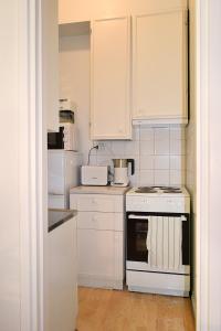 a kitchen with white cabinets and a stove top oven at Studio Ateljee in Helsinki