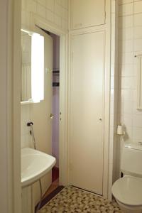 a white bathroom with a sink and a toilet at Studio Ateljee in Helsinki