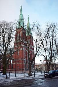 a large red brick building with green towers on a street at Studio Ateljee in Helsinki