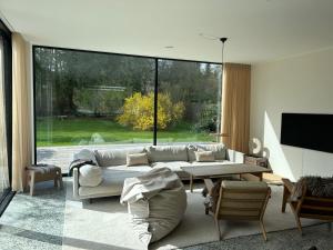 a living room with a couch and a large window at Modern bungalow in forest area in Nærum