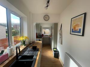 a kitchen with a sink and a clock on the wall at 45 Mold Road in Wrexham