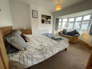 a bedroom with a bed and a couch and windows at 45 Mold Road in Wrexham