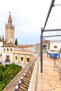 a balcony with a view of a building with a clock tower at AoA Atico Lujo Santa Marta in Seville