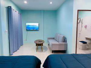 a room with a bed and a couch and a table at NUN GUEST HOUSE in Ban Bo Han