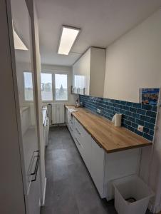 a large kitchen with a wooden counter top at Charmant appartement T3 in Trappes